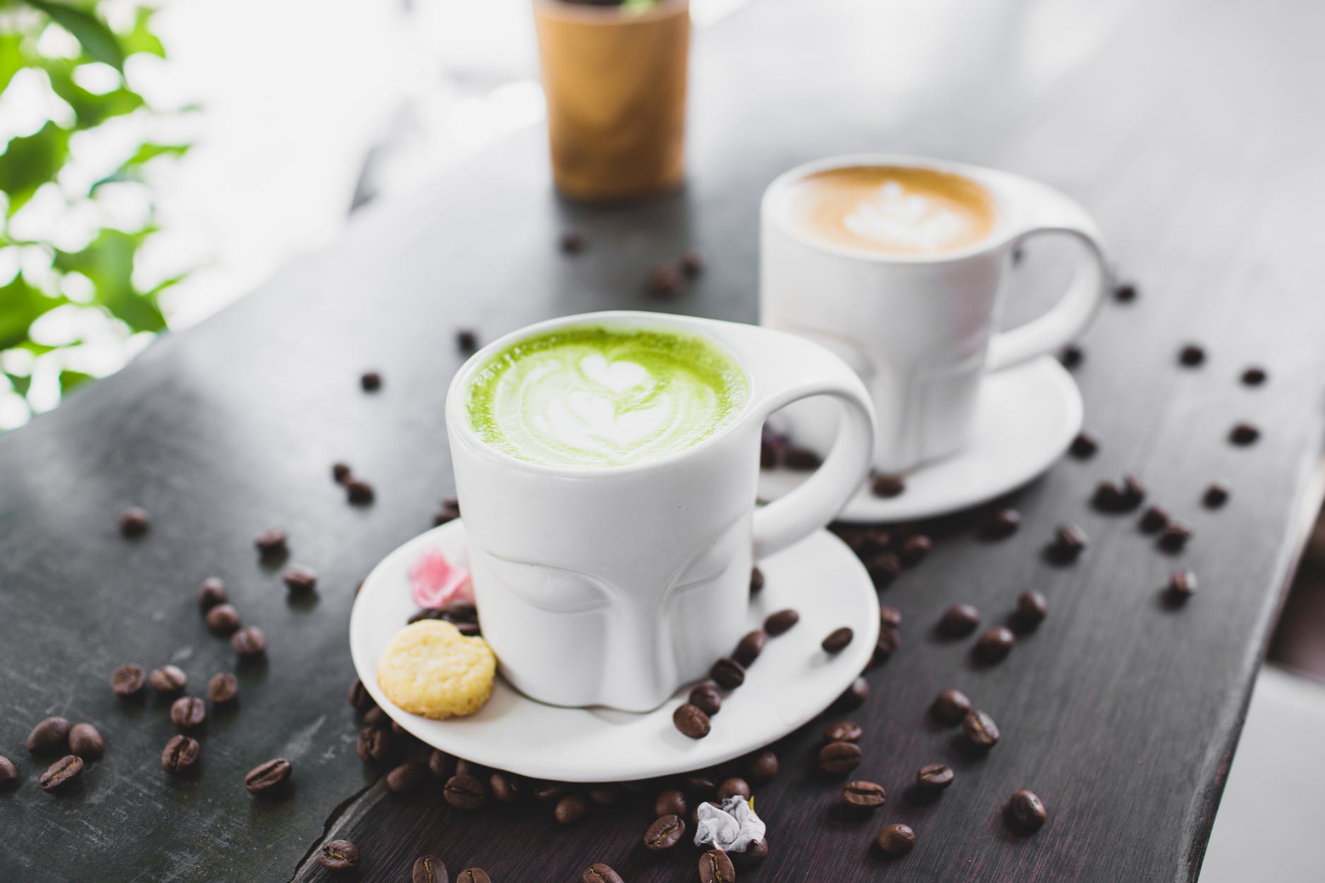 cups of cappuccino and matcha tea served on cafe terrace